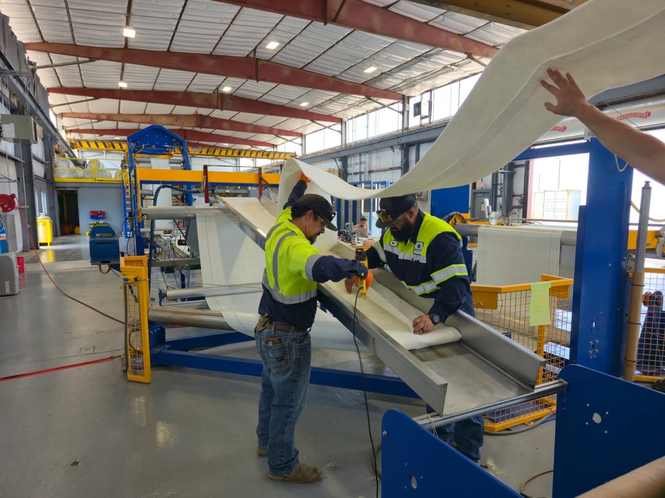 Technicians laying the composite reinforcement onto the production line